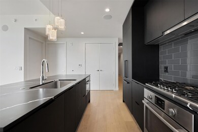 Kitchen featuring dark cabinetry, oven, a sink, a