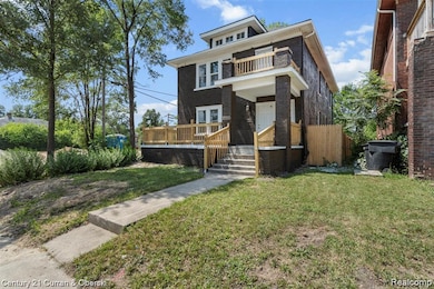 American foursquare style home featuring a front lawn, brick siding, and a balcony