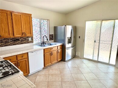 Kitchen with white dishwasher, a sink, stainless s