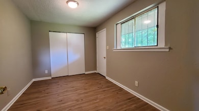 Unfurnished bedroom with wood finished floors, a textured ceiling, and a closet