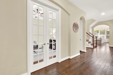 Bright, open hallway with hardwood floors and a st