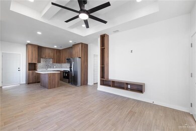 Kitchen featuring a kitchen island, open floor plan, stainless steel appliances, recessed lighting, and tasteful backsplash