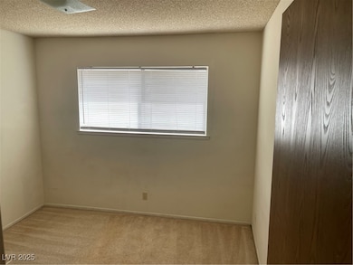 Carpeted empty room featuring a textured ceiling a