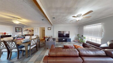 Living room with crown molding, ceiling fan, and a