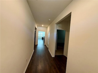 Hall with dark wood finished floors and baseboards