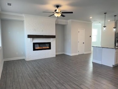 Unfurnished living room featuring a ceiling fan, d