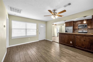 Living room with front door and kitchen in view