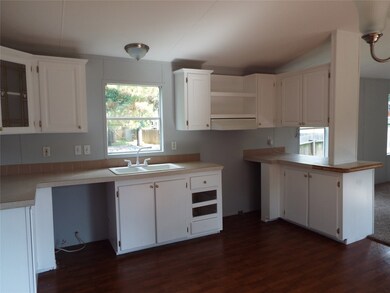 Another view of the kitchen to display the Island on the right separating the living room and kitchen area. A perfect place for a couple of bar stools.
