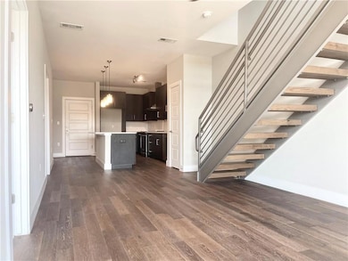 Unfurnished living room with dark wood-style floo