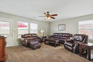 Carpeted living room with ceiling fan