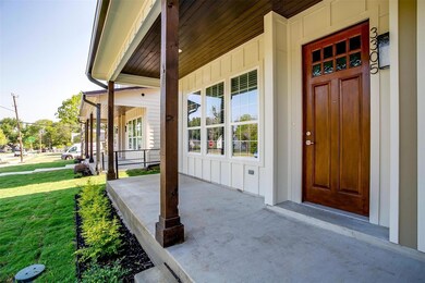 View of exterior entry with a porch and a lawn