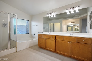 Full bath with a stall shower, a garden tub, double vanity, light carpet, and vaulted ceiling