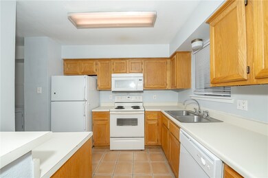 Kitchen with white appliances, a sink, light count