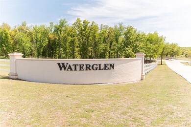 Community / neighborhood sign with a lawn and fence