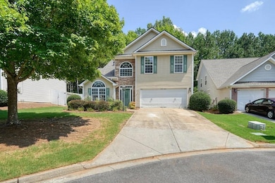 Traditional home featuring driveway, a garage, and a front yard