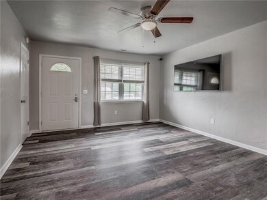 Living room with new flooring, natural light, and 