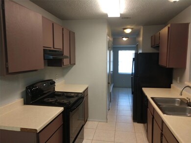 Kitchen featuring black electric range, under cab