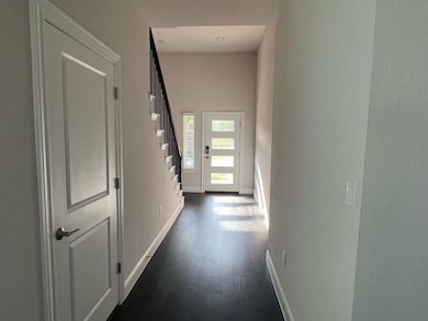 Corridor featuring baseboards, stairs, and dark w