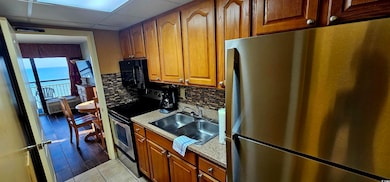 Kitchen with light stone counters, backsplash, lig