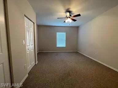 Empty room featuring ceiling fan and baseboards