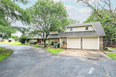 View of front of property with brick siding, asphalt driveway, and a shingled roof