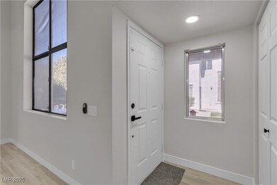Entrance foyer featuring baseboards and light wood