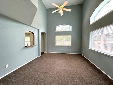 Carpeted empty room featuring a towering ceiling,