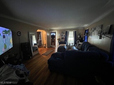 Living room with hardwood / wood-style floors and crown molding