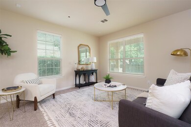 Living room with ceiling fan, baseboards, carpet 
