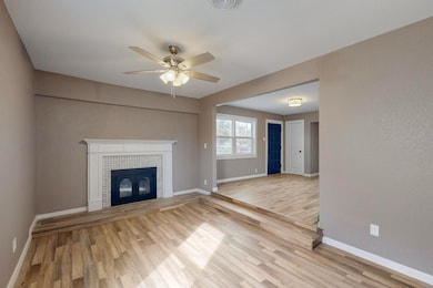 Unfurnished living room with baseboards, light woo