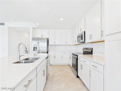 Kitchen featuring stainless steel appliances, light countertops, white cabinetry, recessed lighting, and light tile patterned flooring