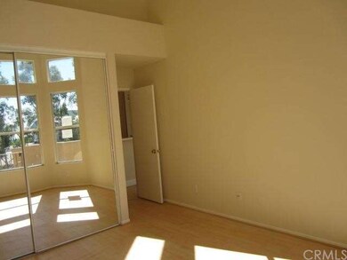 Spacious bedroom with laminate flooring and mirror