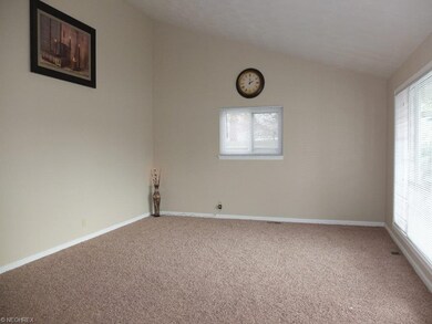Living room with vaulted ceiling and bright pictur