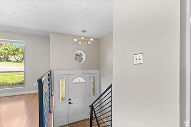 Foyer entrance featuring an inviting chandelier and light hardwood flooring