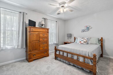 Bedroom with ceiling fan and light carpet
