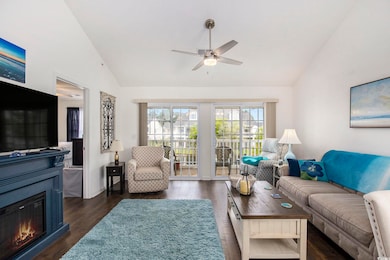 Living area with ceiling fan, dark wood-style floo