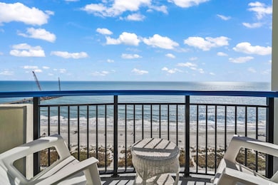 Balcony featuring view of water and beach