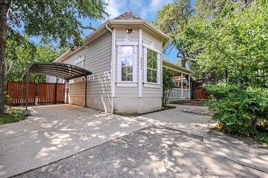 View of side of home with driveway and a carport