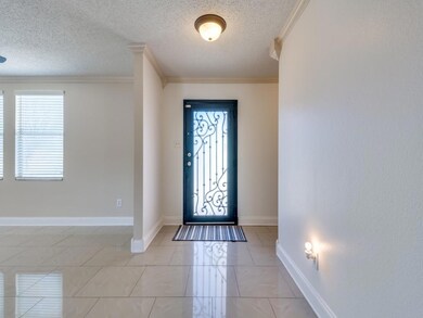 Foyer entrance with a textured ceiling and ornamen