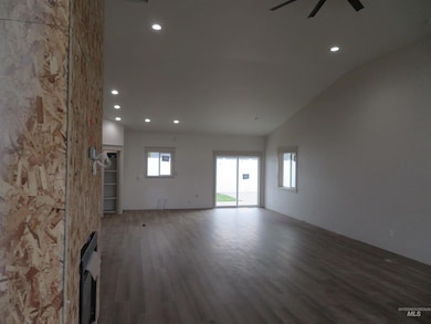 Spare room with recessed lighting, dark wood-style flooring, a fireplace, ceiling fan, and vaulted ceiling
