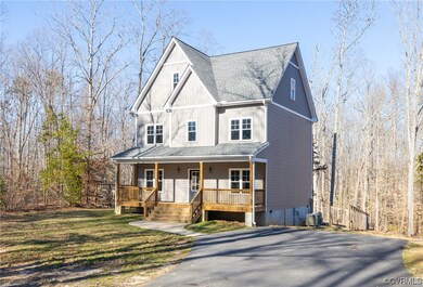 View of front facade featuring covered porch and a front yard