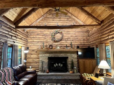Hardwood floored living room featuring log walls, 