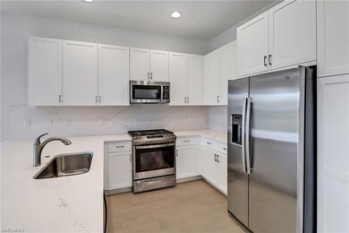Kitchen with white cabinets, sink, tasteful backsp