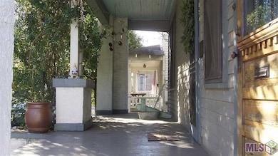 The shaded front porch stretches the full width of
