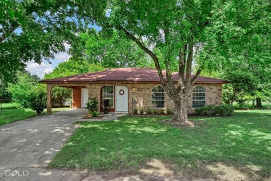 Ranch-style house featuring a front yard and a car