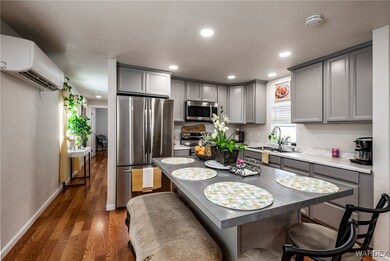 Kitchen with gray cabinetry, appliances with stain