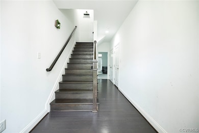 Staircase featuring dark wood-type flooring