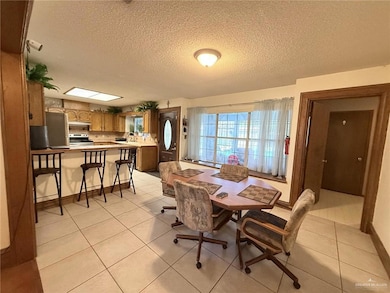 Dining space with a textured ceiling and light tile patterned floors