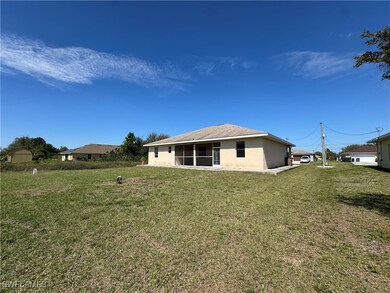 Back of house with a sunroom, a yard, and stucco s