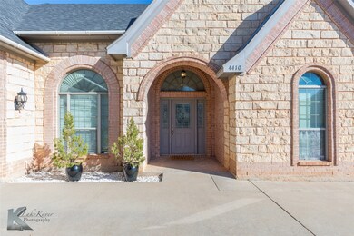 Property entrance featuring brick siding and a shingled roof
